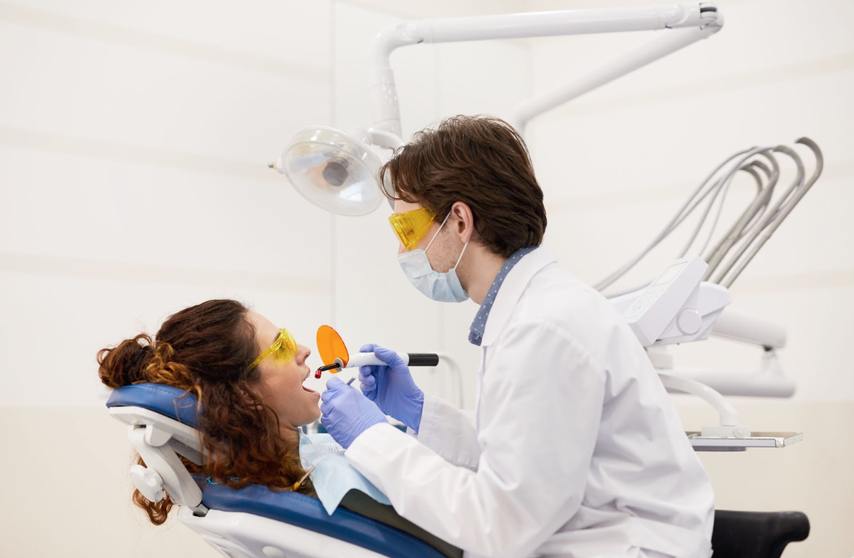 dentist applying teeth whitening treatment