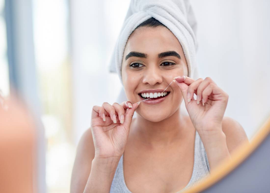 young woman flossing her teeth