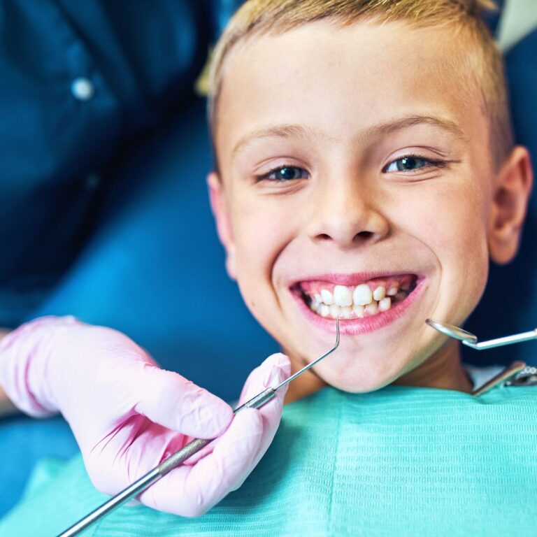 Young boy smiles during dental exam.