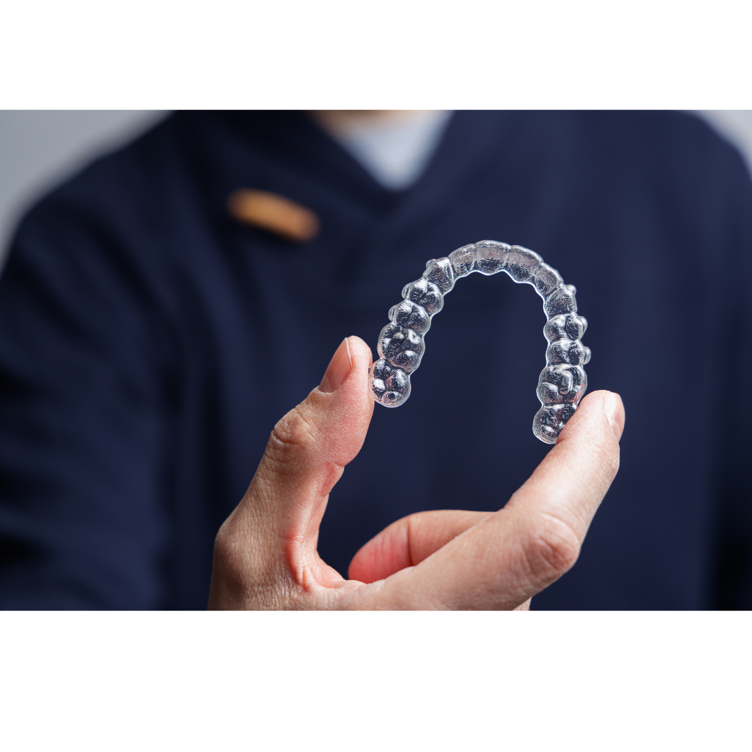 Dentist holds clear aligner