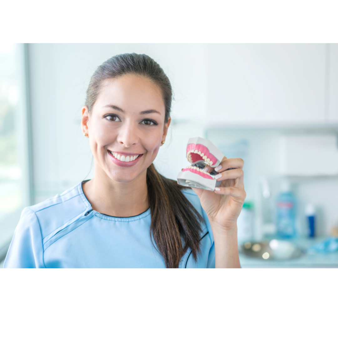 Dentist smiles while holding a pair of dentures