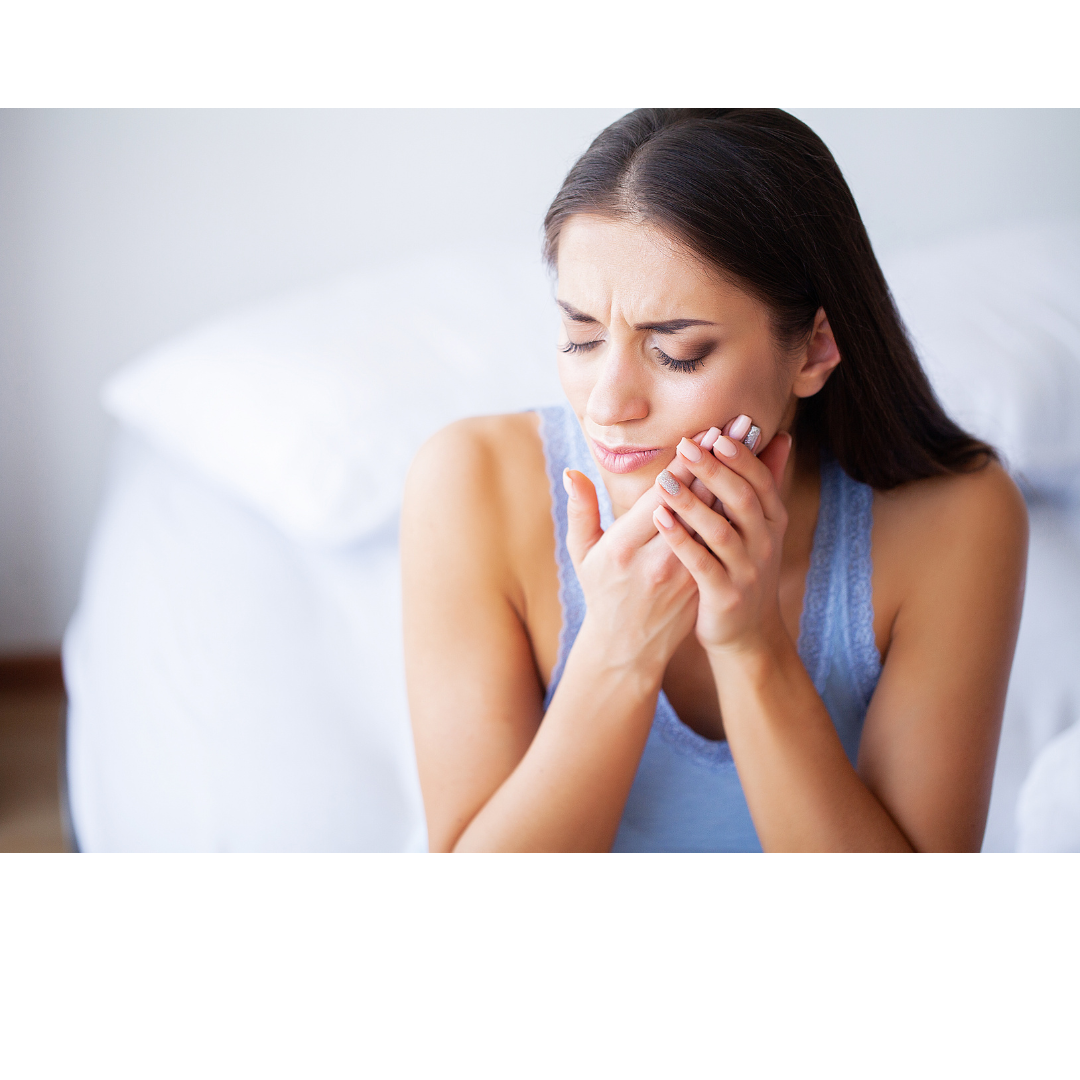 Woman holds her jaw in obvious pain