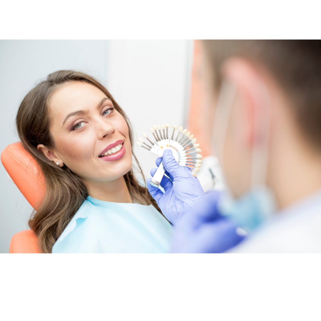 Dental patient smiles while a technician matches her tooth shade.