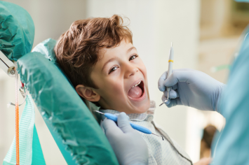 Young boy smiling during dental cleaning at Ames Dentistry